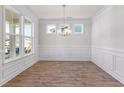 An airy dining room features wainscoting and hardwood flooring, and large windows at 770 Maynard Ln, Summerville, SC 29486