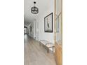 Bright hallway features hardwood floors, a bench and blue heron artwork at 772 Maynard Ln, Summerville, SC 29486