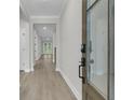 Bright hallway with wood floors, white walls, and a glass door entrance with digital lock at 773 Maynard Ln, Summerville, SC 29486