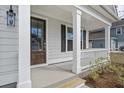 Inviting front porch with white columns, dark door, and stylish outdoor lighting at 778 Maynard Ln, Summerville, SC 29486
