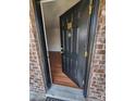 Inviting front door with gold accents, brick surround, and hardwood floors inside at 867 Colony Dr # F 118, Charleston, SC 29407