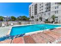 Inviting outdoor pool area with lounge chairs, umbrellas, and a view of the surrounding landscape at 1 King # 702, Charleston, SC 29401