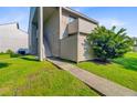 Exterior view of the two-story condo building with sidewalk to front door and healthy green bushes at 1001 Waterwood Dr, Goose Creek, SC 29445