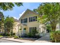 Inviting two-story home featuring a quaint front porch, blue door, and beautiful landscaping at 1033 Mathis Ferry Rd, Mount Pleasant, SC 29464