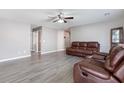 Spacious living room with gray walls, and hardwood floors, featuring an inviting leather sofa and a ceiling fan at 106 Maypop Dr, Goose Creek, SC 29445