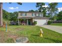 Well-maintained two-story home with a green lawn and mature trees in a quiet neighborhood at 106 Sioux Ct, Summerville, SC 29483