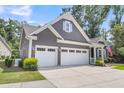 Angled view of a Craftsman-style home with a two-car garage, gray siding, and neat landscaping at 1115 Old Field Dr, Summerville, SC 29483