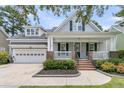 Inviting two-story home with a charming front porch, attached garage, and meticulous landscaping at 114 Marshside Dr, Summerville, SC 29485