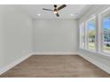 Bright bedroom features a ceiling fan, three large windows, and wood flooring at 1183 Reserve Ln, Awendaw, SC 29429
