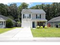 Inviting two-story home featuring a well-manicured lawn and a cozy covered porch at 122 Avalon Rd, Summerville, SC 29483