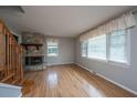 Bright living room featuring hardwood floors, a stone fireplace, and large windows for plenty of light at 1369 Miles Dr, Charleston, SC 29407