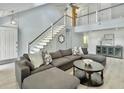 Bright living room featuring staircase, modern decor, vaulted ceilings, and comfortable sofa at 1410 Diamond Boulevard, Mount Pleasant, SC 29466