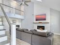 Bright living room featuring modern fireplace, vaulted ceilings, stylish staircase, and comfortable sofa at 1410 Diamond Boulevard, Mount Pleasant, SC 29466