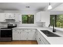 Updated kitchen with black appliances, white countertops and cabinets, and a modern faucet at 1530 Fort Johnson Rd # 2E, Charleston, SC 29412