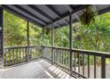 Screened porch with grey wooden deck overlooking lush greenery, offering a serene outdoor space at 1530 Fort Johnson Rd # 2E, Charleston, SC 29412