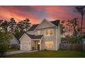 Inviting two-story home featuring a neat, landscaped lawn, an attached garage, and neutral siding at 1989 Nitsa St, Johns Island, SC 29455