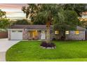 Charming brick home featuring a well-manicured lawn, palm tree, and inviting front porch with seating at 1990 Butternut St, Charleston, SC 29414