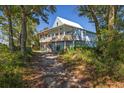 Charming two-story coastal home featuring a spacious covered porch and views of the marsh at 226 Old House Ln, Dewees Island, SC 29451
