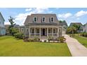 Charming two-story home featuring a covered front porch and meticulously manicured lawn at 2879 River Vista Way, Mount Pleasant, SC 29466