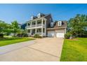 Side view of a two-story home with a two-car garage, long driveway, and well-maintained lawn at 2997 Sturbridge Rd, Mount Pleasant, SC 29466