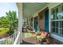 Inviting front porch with cozy seating, a vibrant rug, and views of the well-manicured front yard at 2997 Sturbridge Rd, Mount Pleasant, SC 29466
