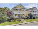 Two-story home featuring double porches, beautiful landscaping, concrete stairs, and a manicured lawn at 312 Germander Ave, Summerville, SC 29483