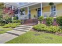 Close-up of the home's front porch with brick and concrete steps, black iron railings, and garden at 312 Germander Ave, Summerville, SC 29483