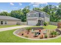 Landscaped backyard with a cozy fire pit area, perfect for outdoor gatherings and relaxation at 352 Matuskovic Dr, Charleston, SC 29414