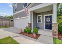 Inviting front porch with stone accents, an American flag, and neatly trimmed shrubs at 352 Matuskovic Dr, Charleston, SC 29414