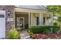 Inviting front porch with stone accents, decorative plants, and cozy seating area at 404 Norwood Ct, Moncks Corner, SC 29461