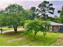 Landscaped front yard showcases the classic brick home with dark shutters, creating a welcoming curb appeal at 4470 Farmwood Ct, Ladson, SC 29456