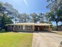Inviting brick home featuring a covered carport and well-kept lawn at 449 Estates Dr, Walterboro, SC 29488
