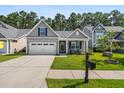 Well-maintained home with neat landscaping, a spacious driveway, and a cozy front porch for relaxing evenings at 491 Foxbank Plantation Blvd, Moncks Corner, SC 29461