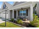 Inviting covered front porch with comfortable seating, lush landscaping, and stylish decor, perfect for relaxing at 491 Foxbank Plantation Blvd, Moncks Corner, SC 29461