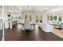 Bright open-concept living area with dining table, couch, and white furniture on dark wood flooring at 55 Seagrass Ln, Isle of Palms, SC 29451