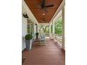 Relaxing porch with wood floors, ceiling fans, rocking chairs, and scenic views of the surrounding greenery at 55 Seagrass Ln, Isle of Palms, SC 29451