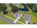 Aerial view of a beautiful home with manicured lawn, adjacent to a tranquil pond in a friendly neighborhood at 7045 Stonecrop Ln, Johns Island, SC 29455
