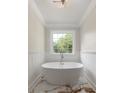 Modern bathroom features a standalone soaking tub, wainscoting and a large window at 7986 Highway 162, Hollywood, SC 29449