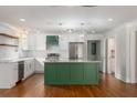 Bright kitchen with white cabinets, stainless appliances, a marble countertop island and hardwood floors at 7986 Highway 162, Hollywood, SC 29449