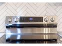 Close-up of a stainless steel electric range with digital controls and a white tile backsplash at 7986 Highway 162, Hollywood, SC 29449