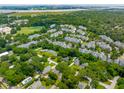 Aerial view showcasing a low-density neighborhood, surrounded by mature trees and with proximity to the coastline at 8 Tovey Rd, Charleston, SC 29407