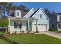 Light blue home with a two-car garage, dormer window, and a manicured lawn, exuding suburban charm at 1009 Field Sparrow Dr # Cc3-2-6, Ravenel, SC 29470