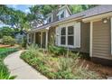 Charming home exterior with walkway, showing manicured garden and traditional siding at 1052 Yorktown Dr, Charleston, SC 29412