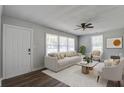Bright living room with neutral furniture, ceiling fan, wood floors, and large windows at 1112 Yeamans Hall Rd, Hanahan, SC 29410