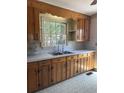 Traditional kitchen featuring wooden cabinets, stainless steel sink, and linoleum flooring at 1674 Garden St, Charleston, SC 29407