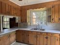 Traditional kitchen with wooden cabinets, stainless steel sink, and window view at 1674 Garden St, Charleston, SC 29407