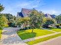 Spacious home with a large driveway, green lawn, and mature trees in a suburban setting at 173 Silver Cypress Cir, Summerville, SC 29485