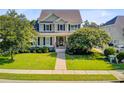 Beautiful two-story home with a lush green lawn, mature trees, and a sidewalk leading to the entrance at 173 Silver Cypress Cir, Summerville, SC 29485
