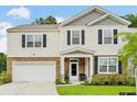 Attractive two-story home with stone accents, a well-kept lawn, and a welcoming entrance at 217 Black Tupelo Ct, Moncks Corner, SC 29461