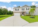 Charming two-story home with a well-manicured lawn and a long driveway leading to the garage at 217 Black Tupelo Ct, Moncks Corner, SC 29461